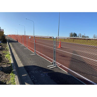 Orange chain link fencing with metal supports, ideal for construction sites or event management.